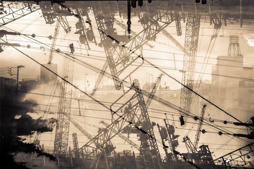 複数の鉄塔とクレーンが立ち並ぶ建設現場の風景