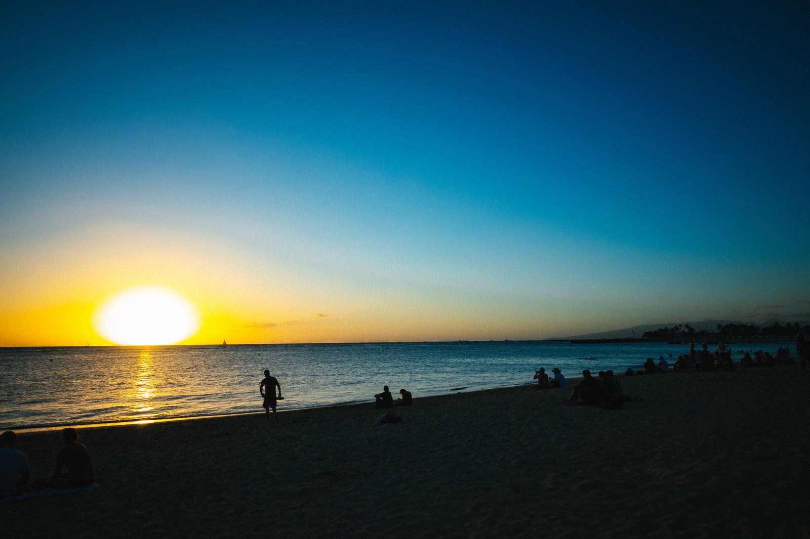 ハワイの海岸で太陽が水平線に沈む夕日の風景