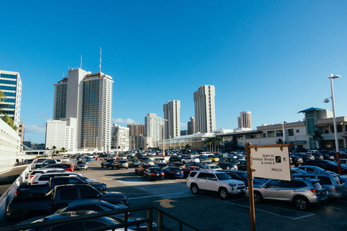 高層ビル群を背景にしたショッピングセンターの駐車場