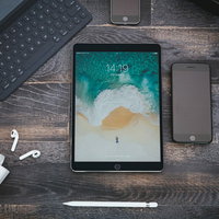 木目調の床に置かれたスマートフォンやタブレットとガジェットの写真