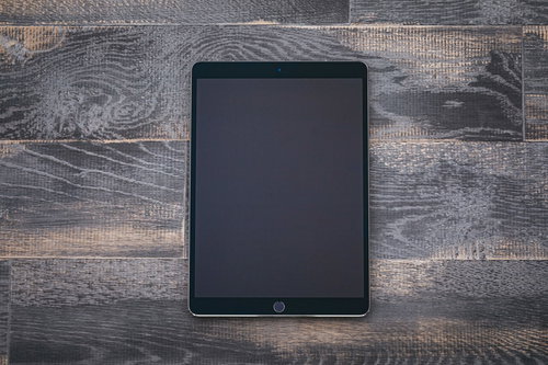 木目調のテーブルに置かれた大画面のタブレット端末