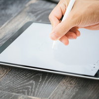 大画面のタブレットで絵を描く絵師の手元とペン操作の写真