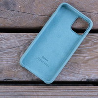 木の板の上に置かれたiPhoneの純正シリコンケースの写真