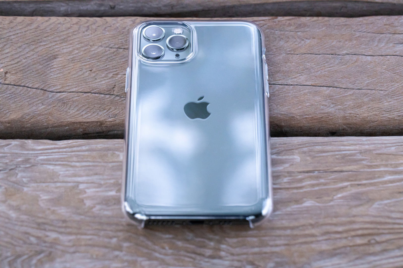 木製テーブルに置かれたiPhone 11 Proと透明ケース