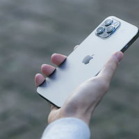 右手で握りしめる白いiPhone 12 Proの写真