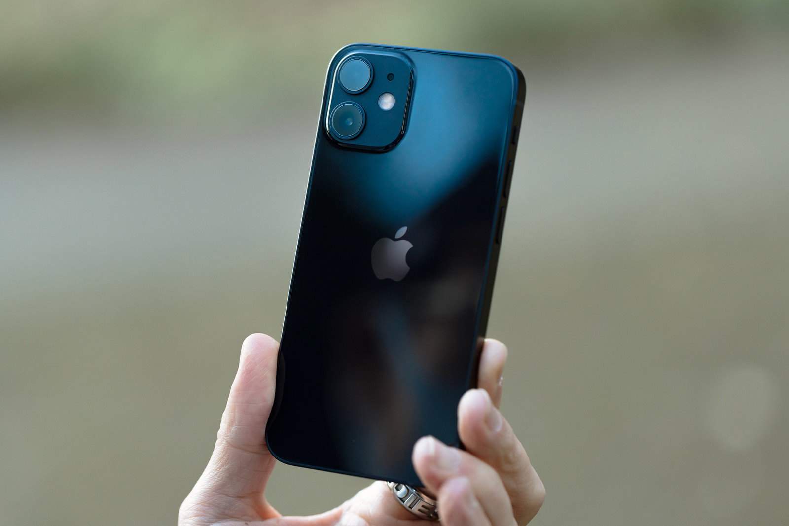 太陽光に照らされたiPhone 12を手に持っている様子