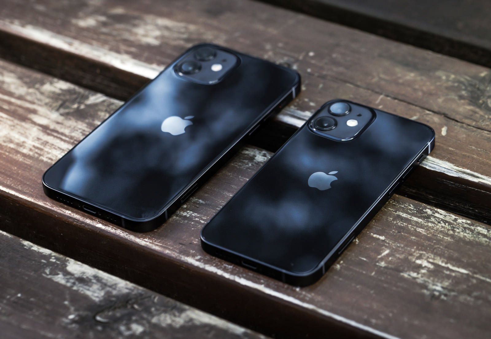 木製ベンチに並べて置かれたiPhone 12とiPhone 12 mini