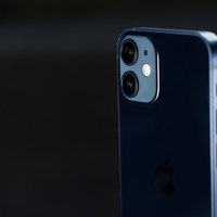 暗闇に浮かび上がるiPhone 12のシルバーフレームの写真