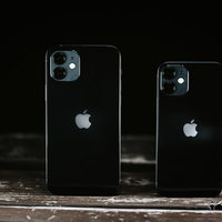 木目調の表面に並べたiPhone 12とiPhone 12miniの写真
