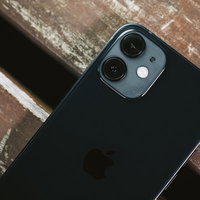 木製テーブルの上に置かれたiPhone 12のリアカメラ部分の写真