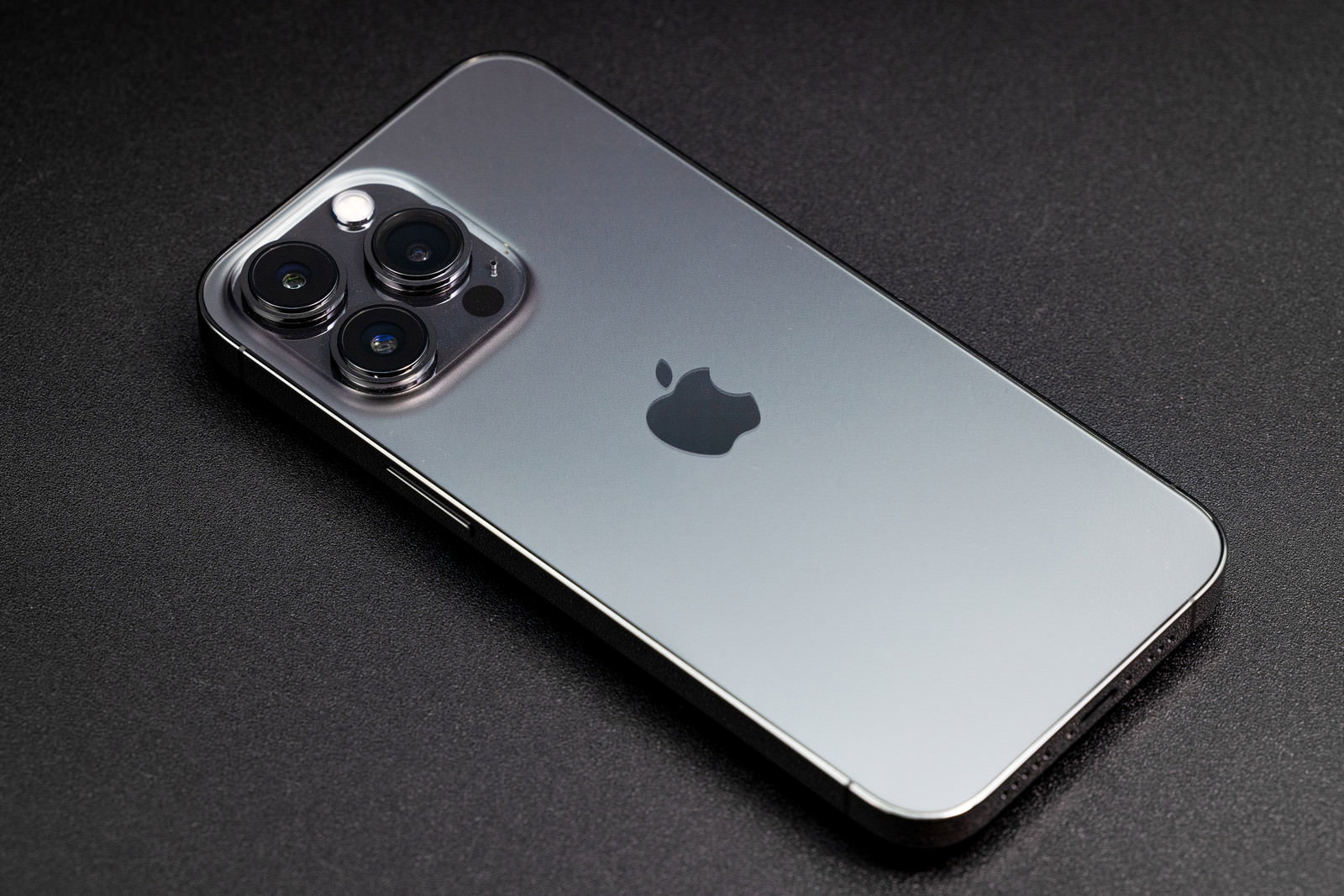 グレーの背景に置かれたiPhone13 Pro シエラブルーの端末