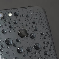 水に濡れた黒いスマートフォンの背面の写真