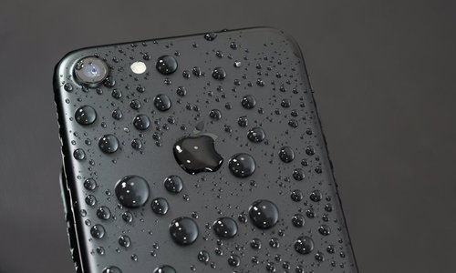 水に濡れた黒いスマートフォンの背面
