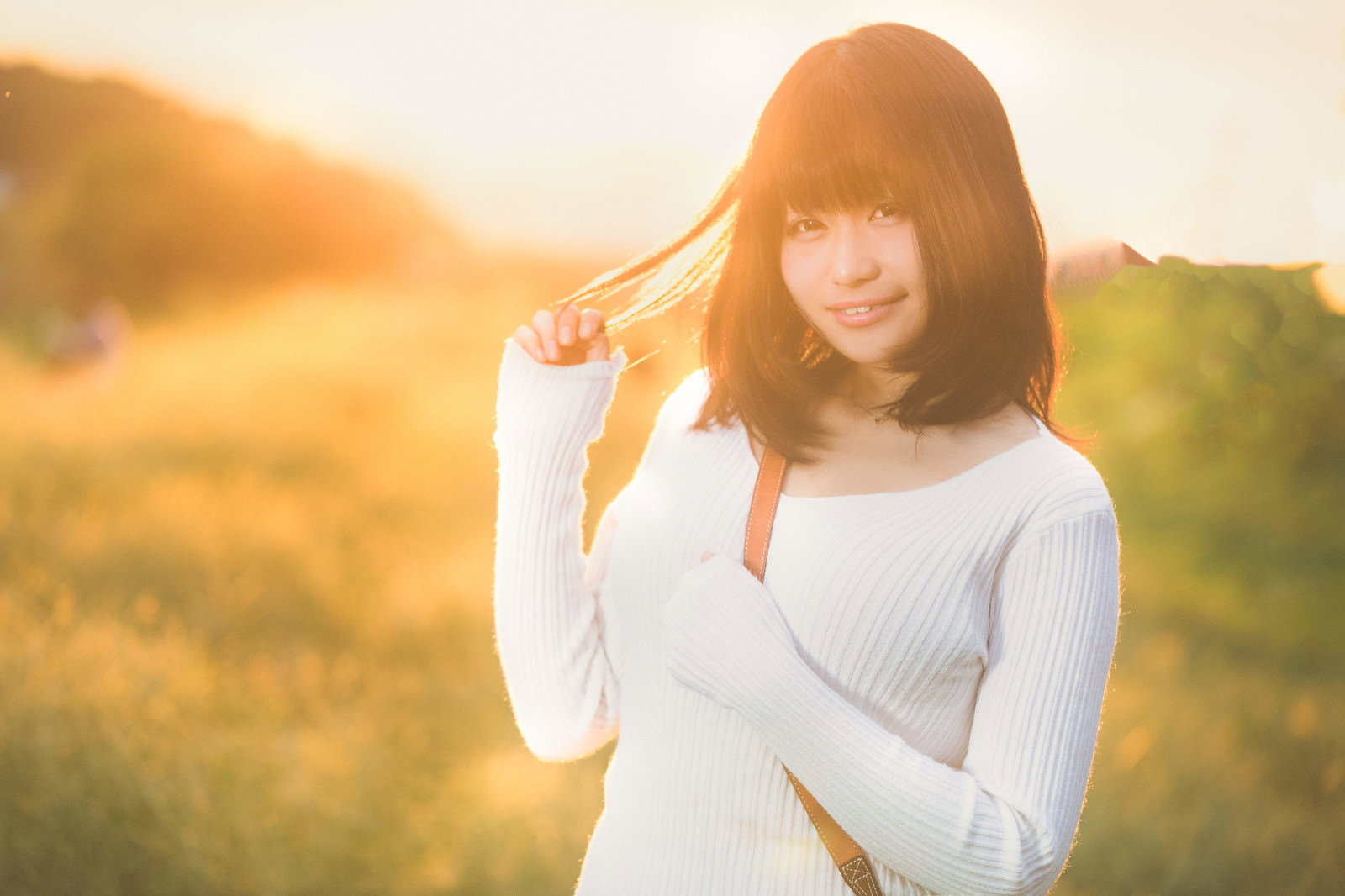 マジックアワーの草地で彼女をスマホで撮影［モデル：茜さや］