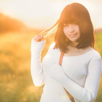 オレンジ色の夕焼け（マジックアワー）と美女をスマホで撮影する彼女の写真