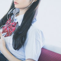 通学中にスマホで音楽を聴く女子高生、有線イヤホン姿の写真