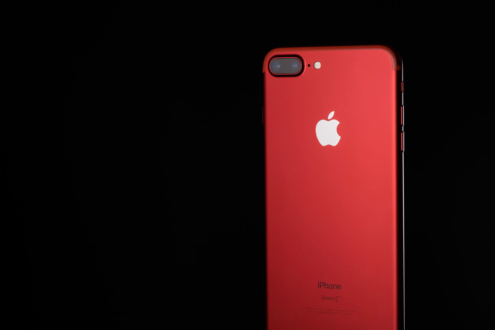 黒背景に立てかけた赤いiPhoneの背面