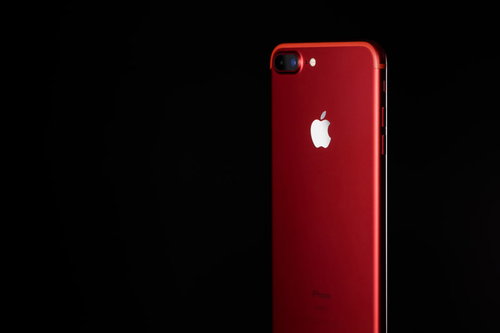 黒背景に配置された赤いiPhone