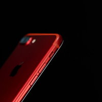 黒背景に映える赤いカラーモデルのスマートフォンの写真