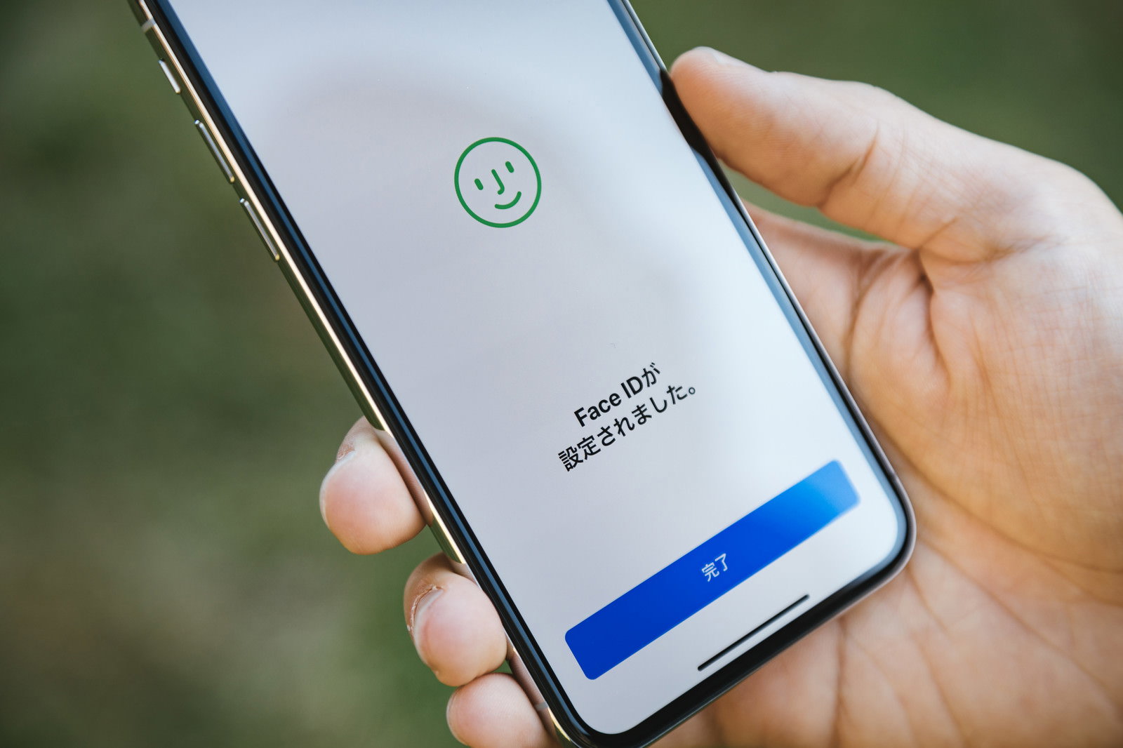 iPhone Xの画面に顔認証完了のチェックマークが表示されている様子