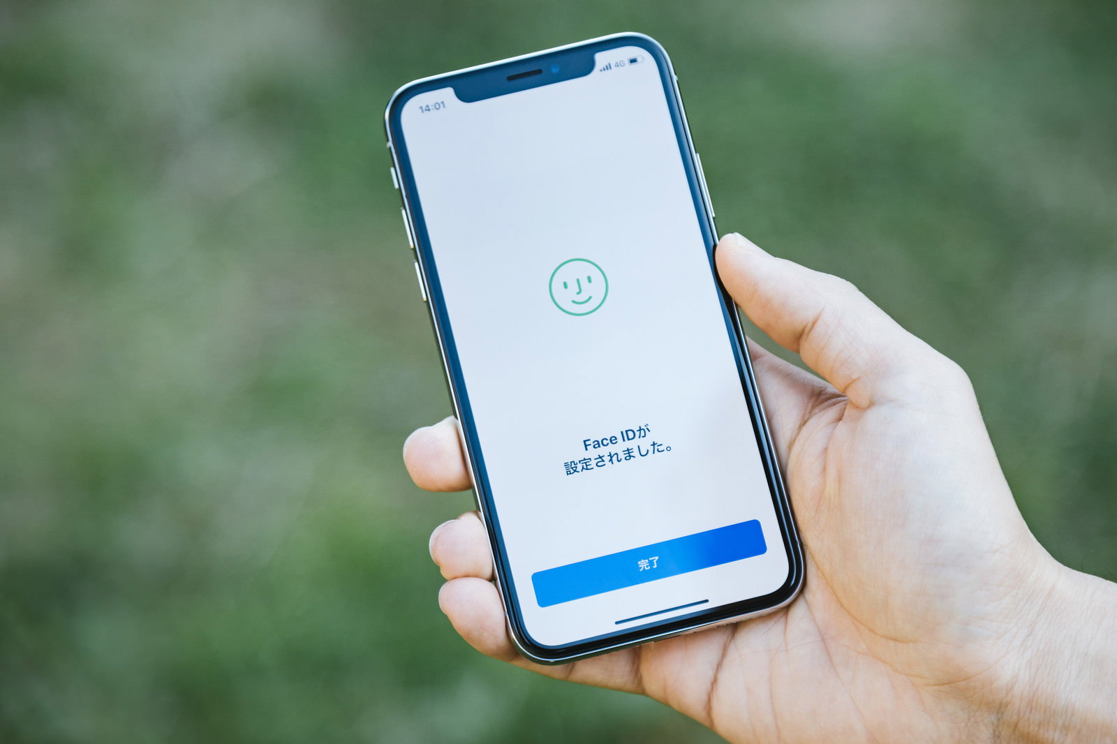 iPhoneXのFace IDセットアップ画面を手で持つ