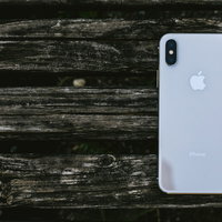 古い木目の板に置かれたiPhone Xのスマートフォンの写真