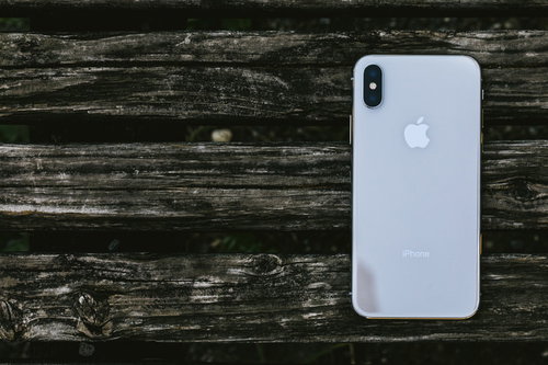 古い木目の板に置かれたiPhone Xのスマートフォン