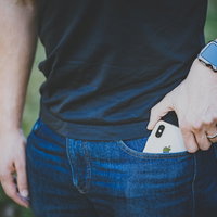 ジーンズのポケットからiPhone Xを取り出すシーンの写真
