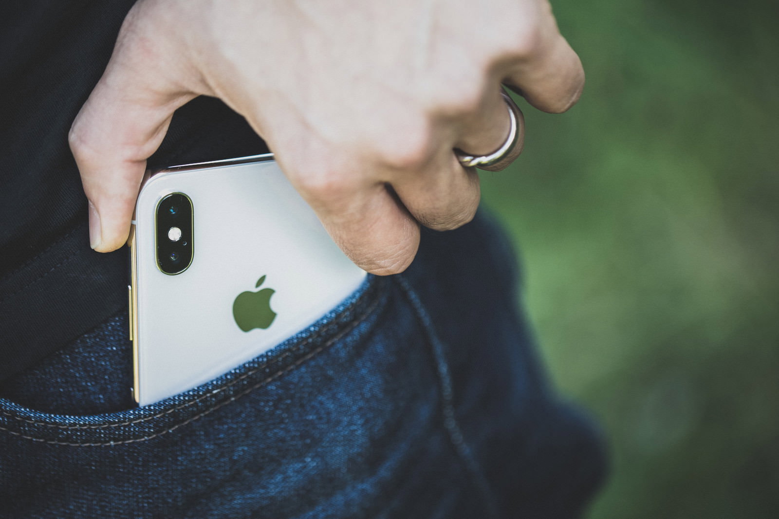 ジーンズのポケットからiPhone Xを取り出す男性の手
