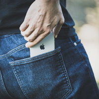 ジーンズの後ろポケットから iPhone X を取り出す手元の写真