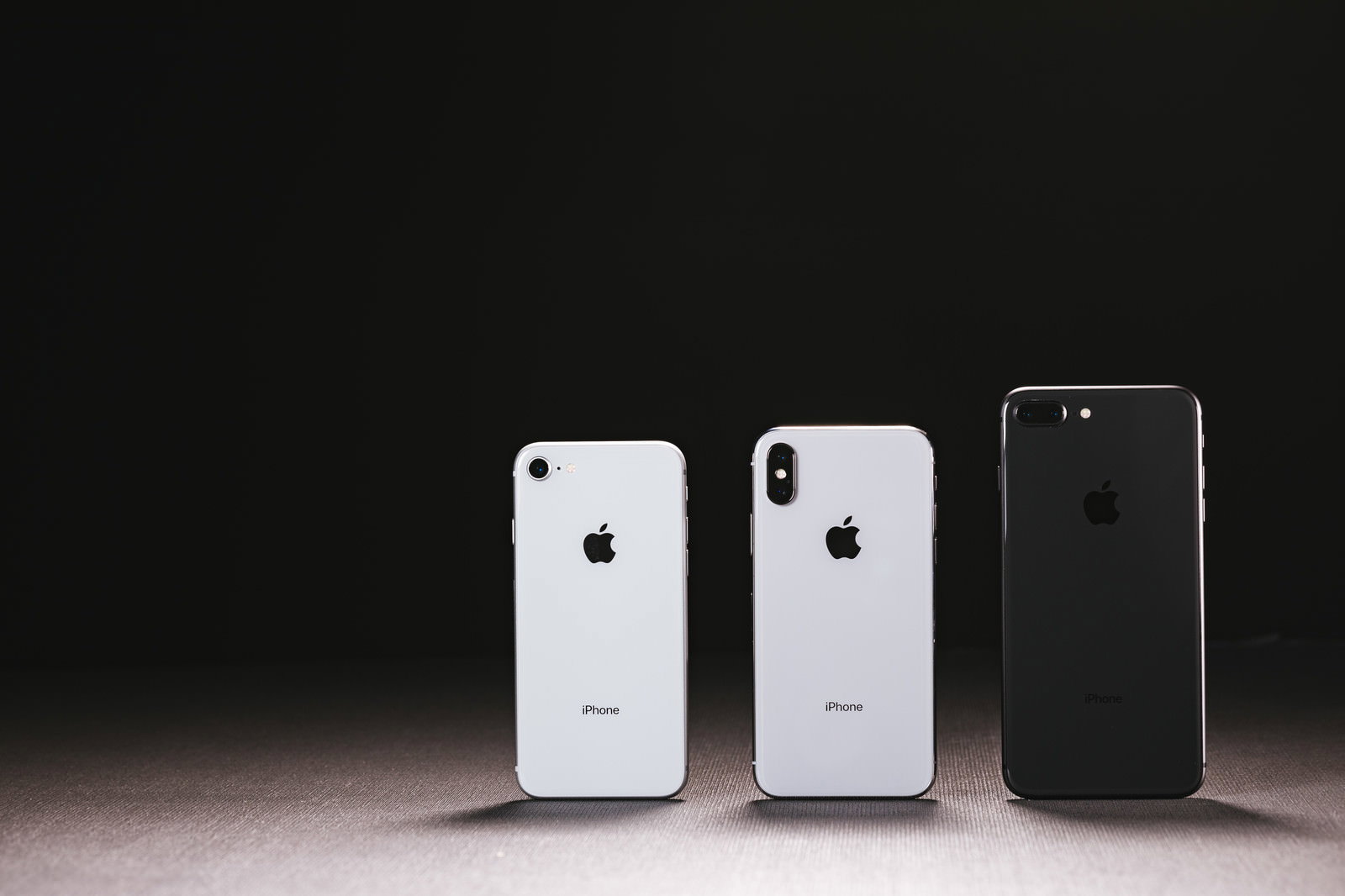 黒い背景に並べて配置されたiPhone XとiPhone 8