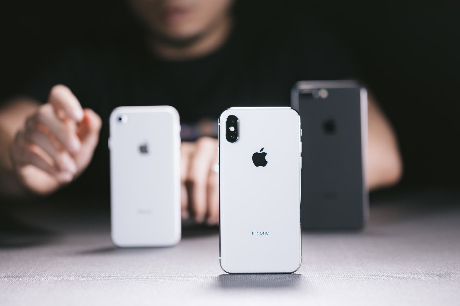 iPhoneを3台並べて比較する男性