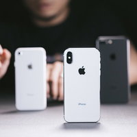 iPhone 8 / X / 8 Plus を並べる男性の写真