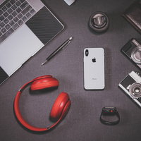 iPhone Xと赤いヘッドフォンなどのガジェット製品の写真