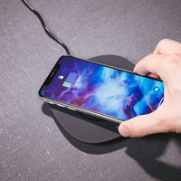 ワイヤレス充電器にスマートフォン（iPhone X）をかざすの写真