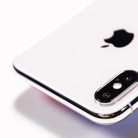 iPhone X の白いボディに配置されたデュアルレンズカメラの写真
