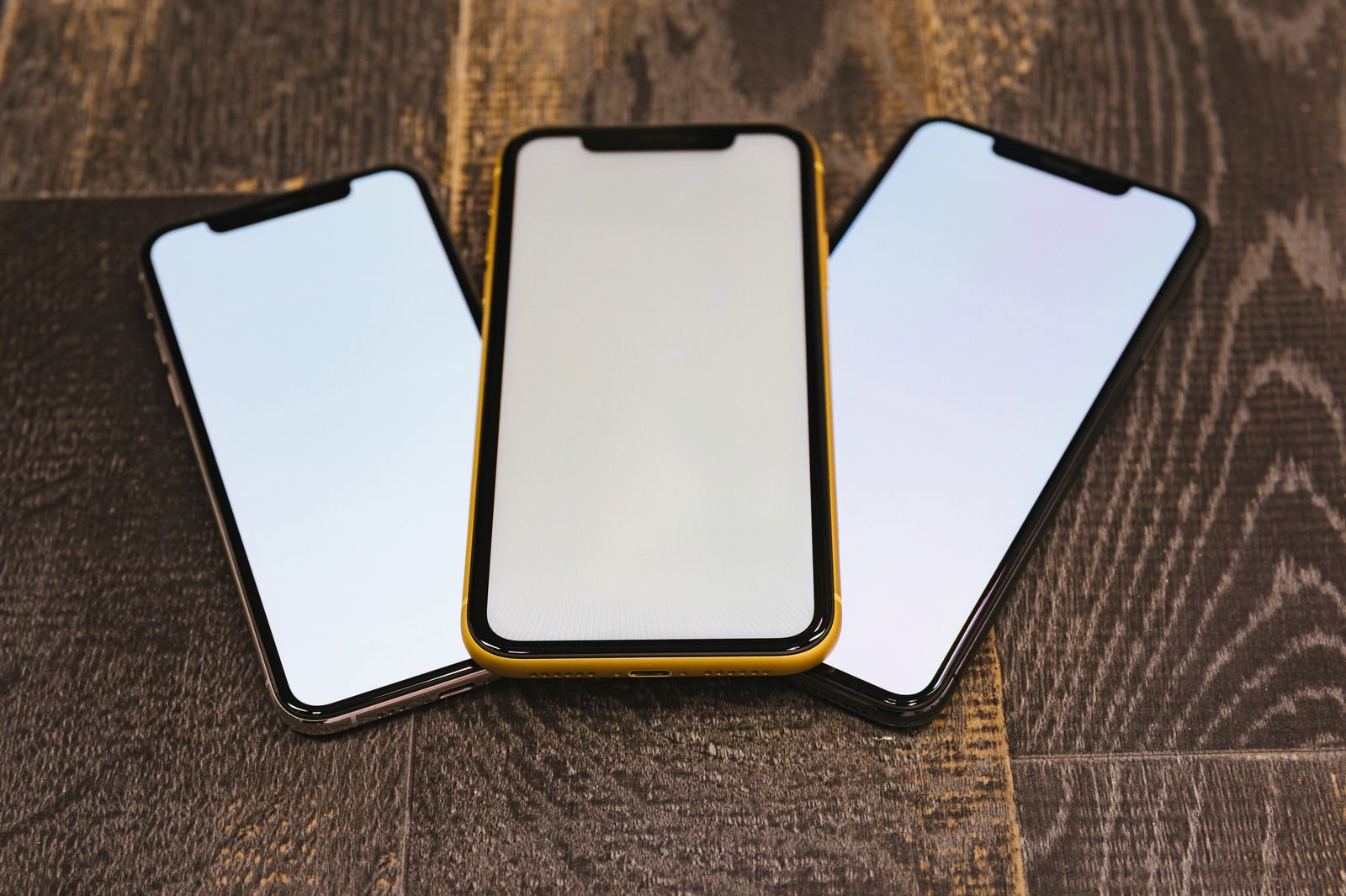 木目のテーブルに並べられたiPhone XSとXRの画面比較