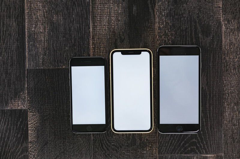 iPhone X の全画面表示を手に持って撮影している様子の写真素材