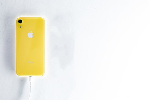 iPhoneをケーブル充電する黄色のiPhone XR