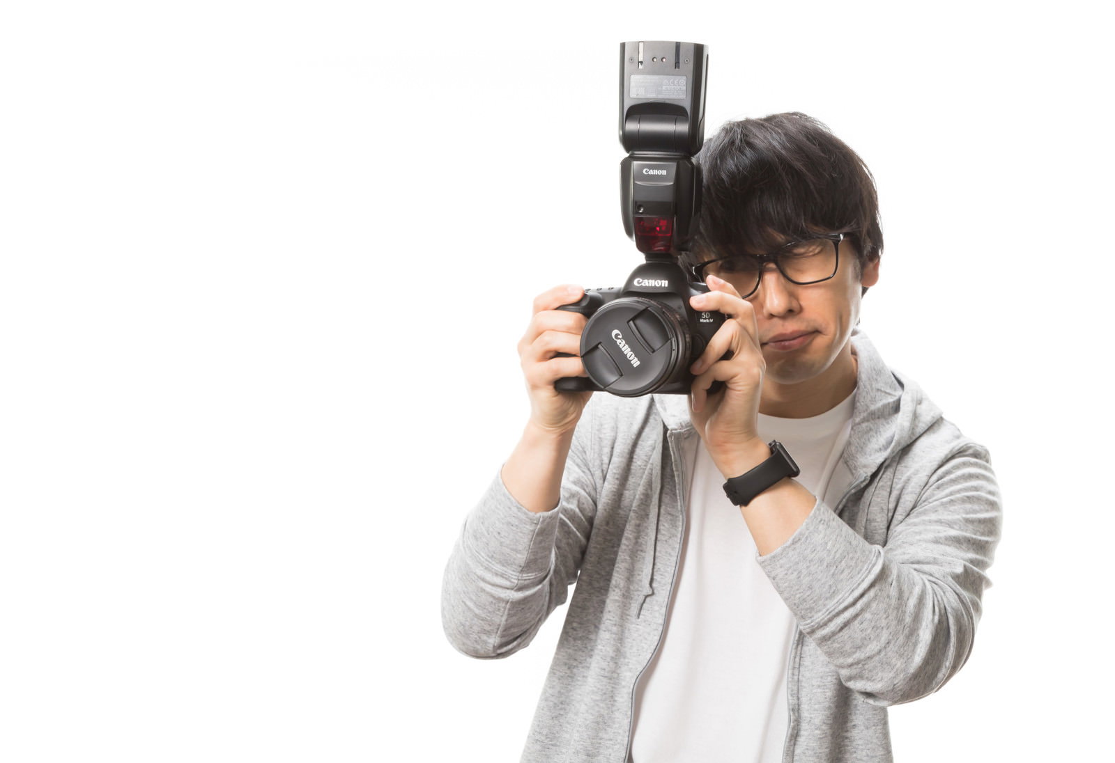 レンズキャップを付けたまま撮影しようとする眼鏡の男性カメラマン［モデル：大川竜弥］
