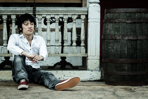 貴重品を失くして無一文になった男性がスーツケースの横で落ち込む