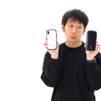 白黒つけられない優柔不断なスマホユーザー、iPhoneの色選びで迷う男性の写真