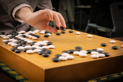 囲碁の対局で耳赤の一手を探る～木製碁盤での黒石と白石の緊迫した局面