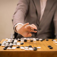 本因坊秀策の赤耳の一手を再現、黒石を打つ瞬間のプロ棋士の手元の写真