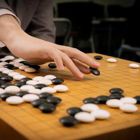 名局・赤耳の一手を再現するプロ棋士の手元と囲碁盤面の写真