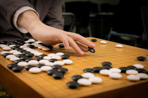 名局・赤耳の一手を再現するプロ棋士の手元と囲碁盤面