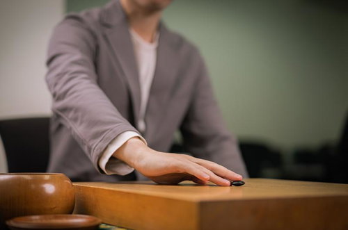 天元からはじまる囲碁の対局、黒石と白石を配置した碁盤での対戦の様子