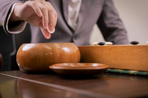 碁笥から石をつかむときは、指三本。指二本でつかむ人はまだまだ経験が浅い。