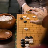 互いの主導権を争う黒白の接近戦、木製の碁盤で繰り広げられる対局直前の写真