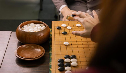 互いの主導権を争う黒白の接近戦、木製の碁盤で繰り広げられる対局直前